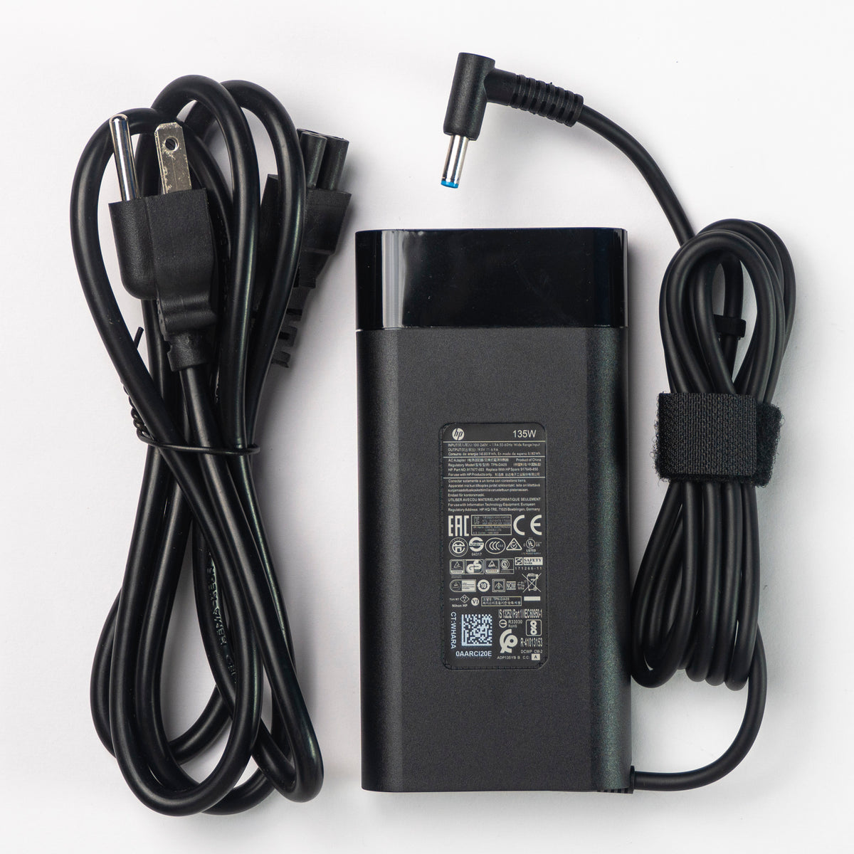 Especificaciones de voltaje 19.5V y amperaje 6.9A impresas en cargador HP TPN-CA13